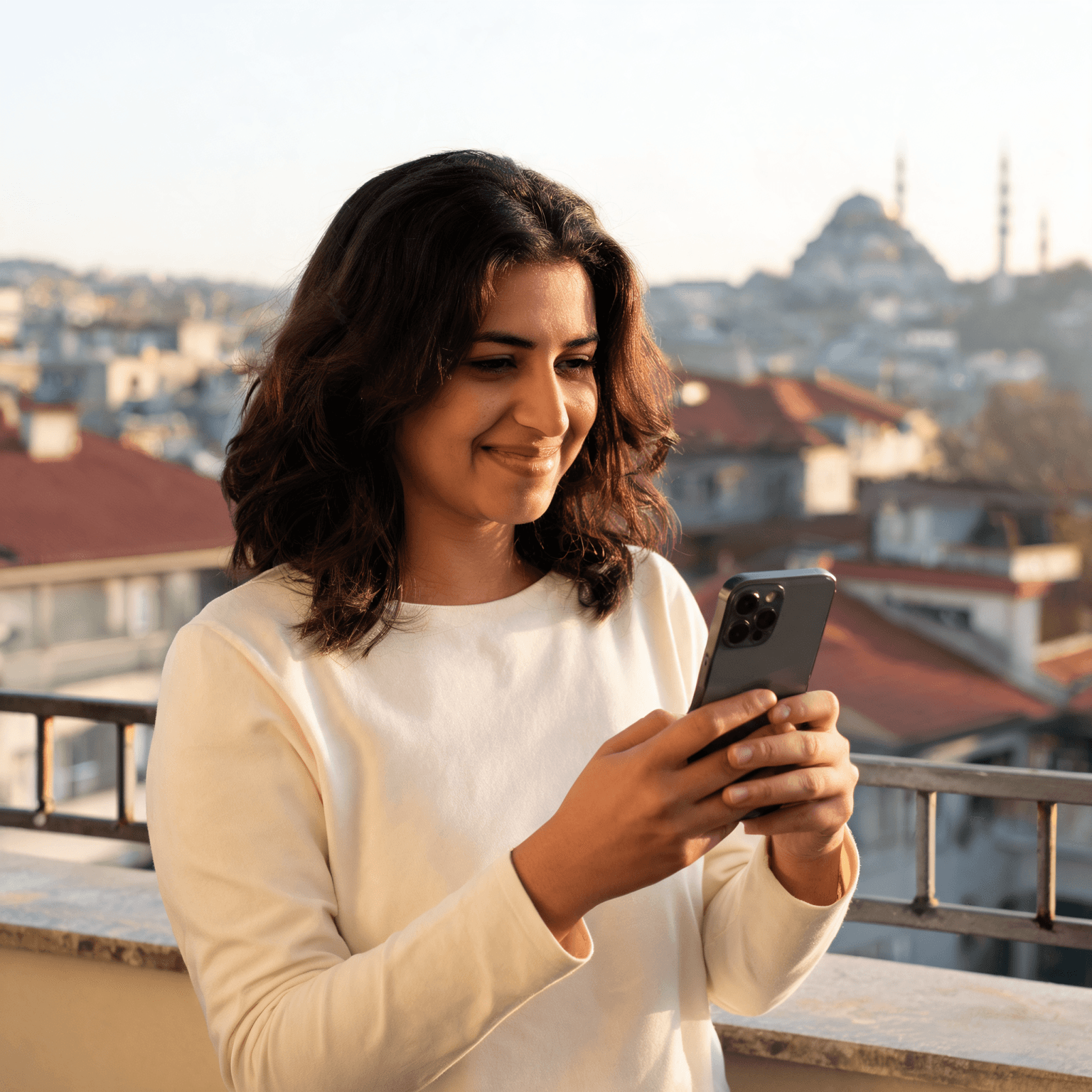 Telefonunda güzel bir haber okuyup gülümseyen genç biri